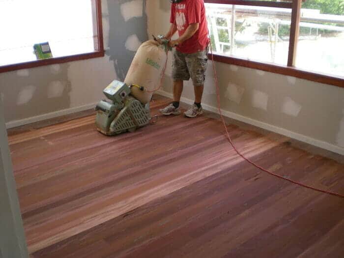 man sanding a hardwood floor