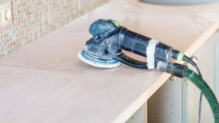 an orbital sander being used to remove water stains from wood